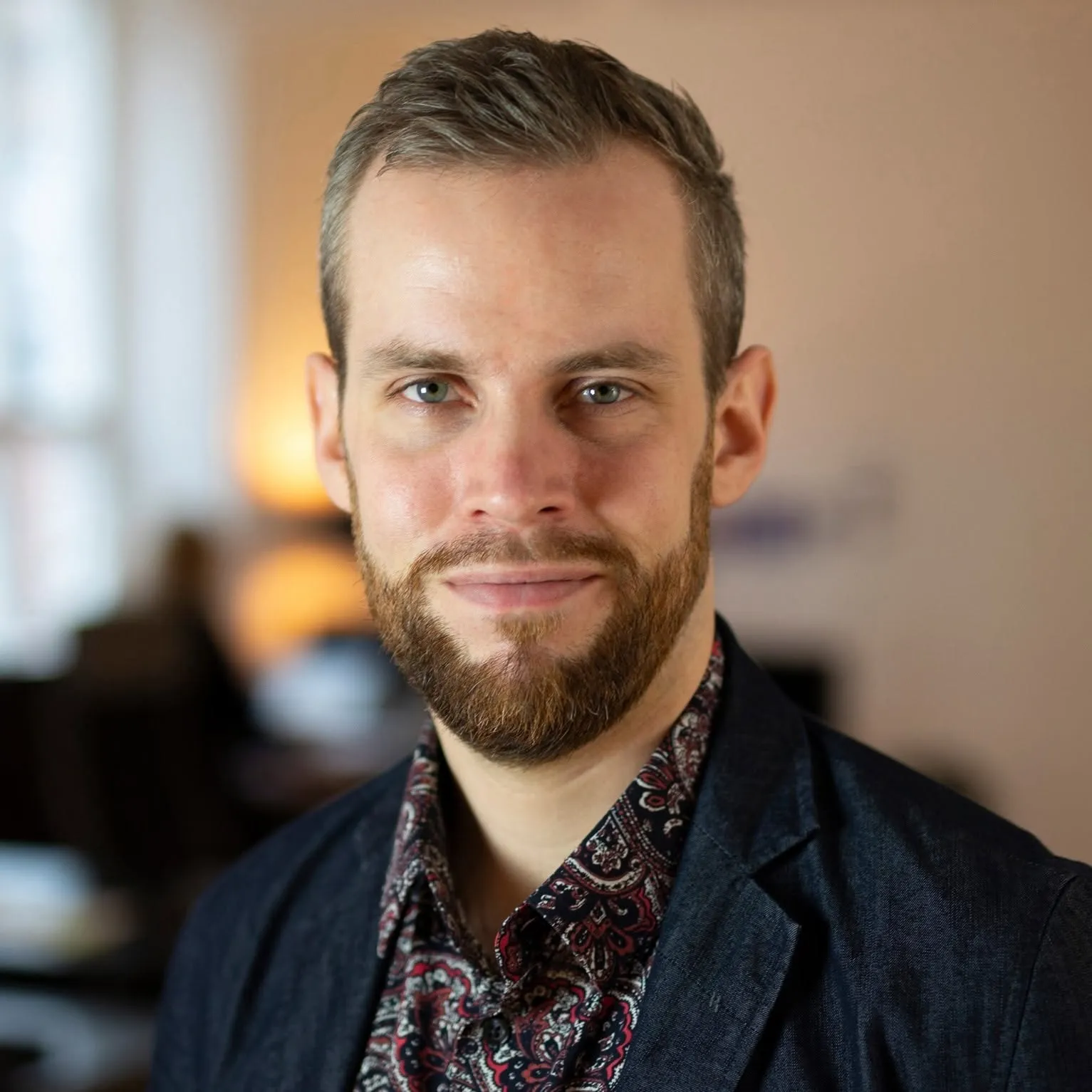 Portrait of Joakim Bergman in a dark jacket and patterned shirt